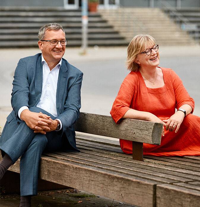 Die Geschäftsführung Alf Aleithe und Silke Andresen-Kienz auf einer Bank Die Geschäftsführung Alf Aleithe und Silke Andresen-Kienz auf einer Bank